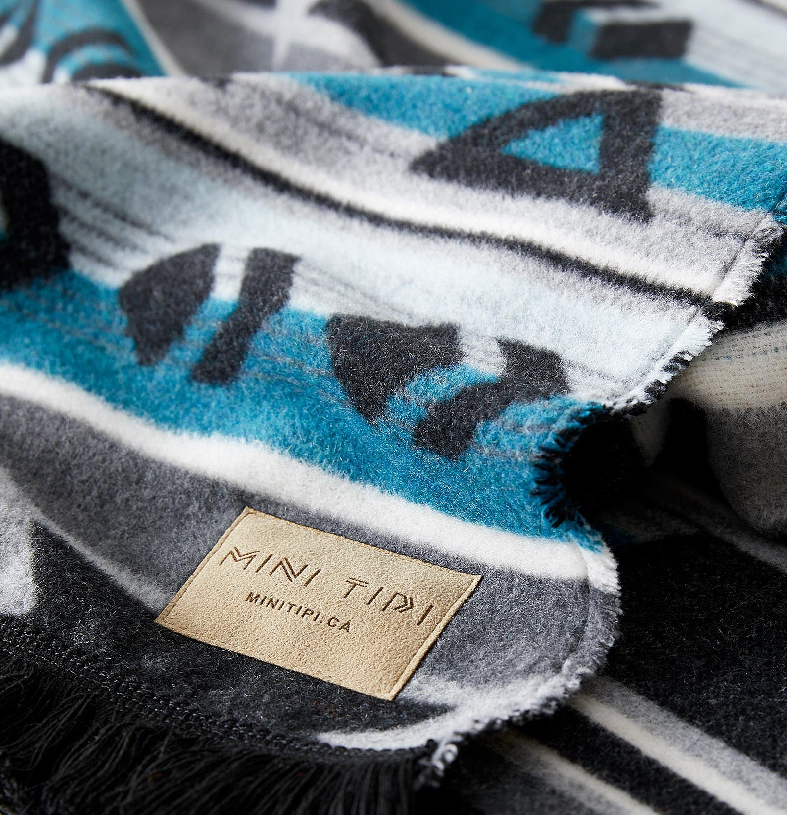 Textured fabric with a brand label saying &quot;MINI TIPI&quot;