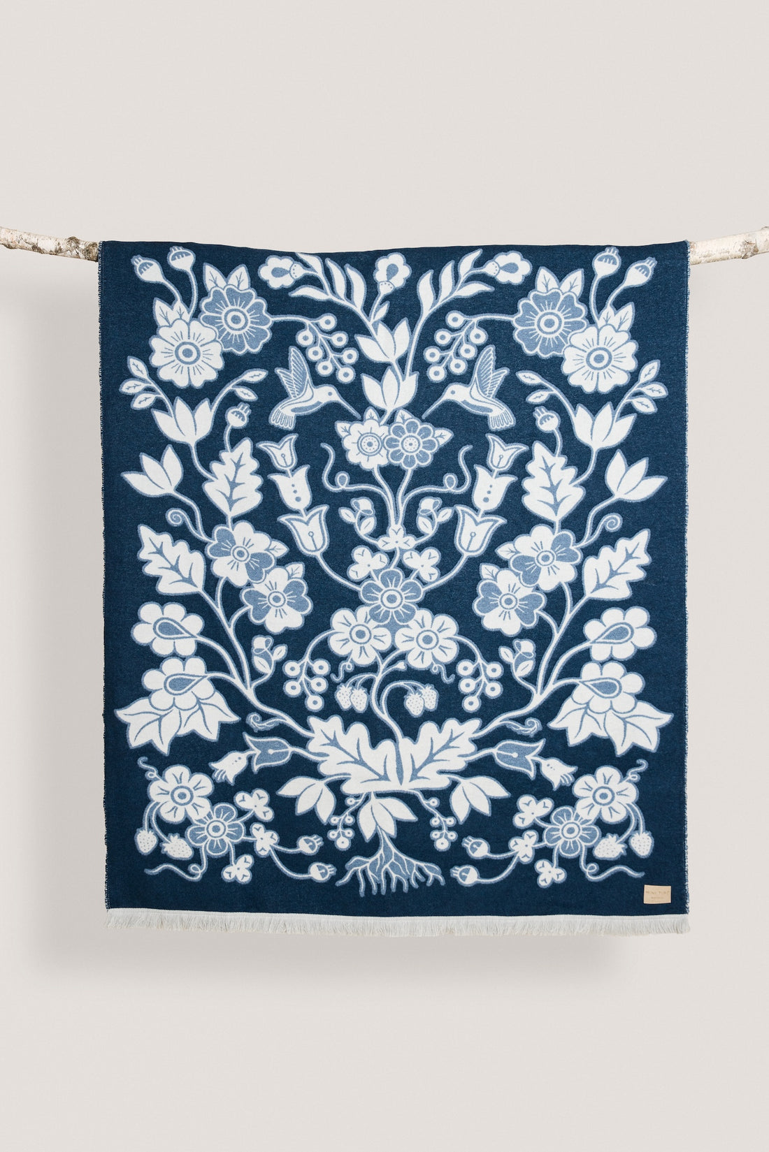 Navy blue wool blanket with a white floral pattern on a white background